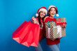 © deagreez - Photo of excited dreamy ladies santa helpers dressed print sweaters buying xmas presents empty space isolated blue color background
