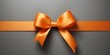 Orange gift ribbon with a bow against a gray background