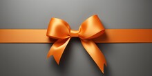 Orange Gift Ribbon With A Bow Against A Gray Background