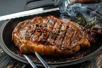 Wall Mural - grilled marbled beef steak striploin with spices in a grill pan. place for text, top view