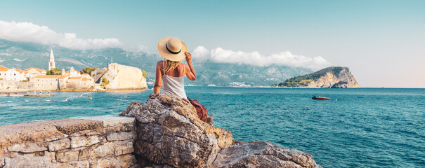 Wall Mural - young female tourist looking at panoramic view of budva old town- travel, tour tourism, vacation in 
