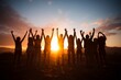 Inspirational team moment Silhouettes celebrate by raising their hands together