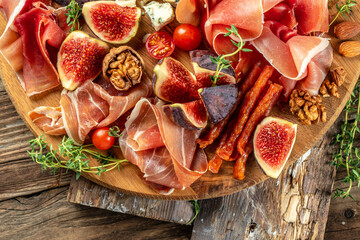 Wall Mural - apetizer platter. dry cured ham, prosciutto slices with figs and cheese. Delicious balanced food concept