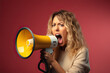© photobuay - Empowered Voice Energetic Young Blonde Woman Amplifying Her Message Through a Megaphone in a Powerful Display of Expression. created with Generative AI
