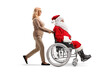 © Ljupco Smokovski - Full length profile shot of a woman pushing santa claus in a wheelchair