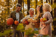 © bernardbodo - Family holding pumpkins and squashes in the woods