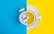 Collage of white alarm clock and white cup with fresh halved orange on the colored  background. Top view.