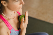 A Woman Does Self - Massage With A Small Ball While Sitting In A Fitness Room . Myofascial Relaxation