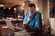 © Marko Geber - Middle aged man going over financials with a smartphone at home during night