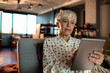 © Marko Geber - Mature woman using a tablet on the couch at home
