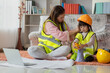 Asian mother helping daughter wearing engineer helmet, education and occupation concept