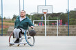 athlete in wheelchair practicing dribbling movement in basketball court