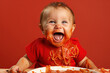 baby laughing with spaghetti sauce mess