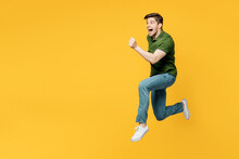 Full Body Side Profile View Young Sporty Cool Fun Happy Man He Wearing Green T-shirt Casual Clothes Jump High Run Fast Hurry Up Isolated On Plain Yellow Background Studio Portrait. Lifestyle Concept.