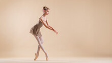 Beautiful Young Girl Professional Student Ballerina In Pointe Shoes And A Leotard On A Light Beige Background.