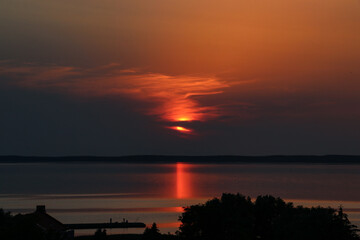 Wall Mural - The burgundy setting sun covered with dark clouds