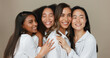 © N Felix/peopleimages.com - Women, group skincare and beauty with love, hug and support in diversity and inclusion on brown studio background. Friends, model or people smile together and kiss in dermatology, skin care or makeup