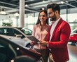 © Banana Images - A car salesman and a customer discussing a purchase at a dealership, finalizing the deal