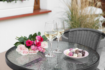 Sticker - Bouquet of roses, glasses with wine and candies on glass table on outdoor terrace