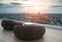 Woven Wicker Seamless Pattern Table And Chairs Is Basketwork By Weaving Plastic Strands To Oval Or Sphere Shape . Brown Wicker Sofa On The Rooftop For See View Of The City With Sunlight Background.