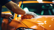 Close-up shot of a worker's hands gripping a car wash sponge as they meticulously clean a vehicle