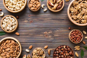 Wall Mural - mixed nuts in wooden bowl. Mix of various nuts on colored background. pistachios, cashews, walnuts, hazelnuts, peanuts and brazil nuts