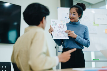 Wall Mural - Group of asian creative team programing designers participate in all phases of the UX UI design.