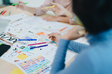 Wall Mural - Group of asian creative team programing designers participate in all phases of the UX UI design.