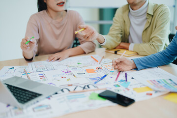 Wall Mural - Group of asian creative team programing designers participate in all phases of the UX UI design.