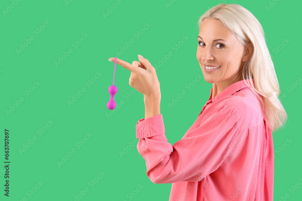 Mature woman with anal plug on green background