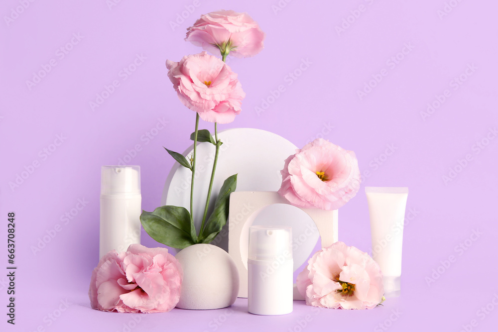 Composition with different cosmetic products, plaster podium and beautiful eustoma flowers on purple background