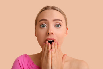 Wall Mural - Surprised young woman on beige background