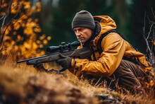 Hunter During Hunting In Forest. Hunter Holding A Rifle And Aiming At Deer. Hunting Expedition In The Forest Wearing Brown Jackets And Reflective Gear