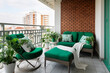 Modern cozy balcony interior design with brick wall and green furniture