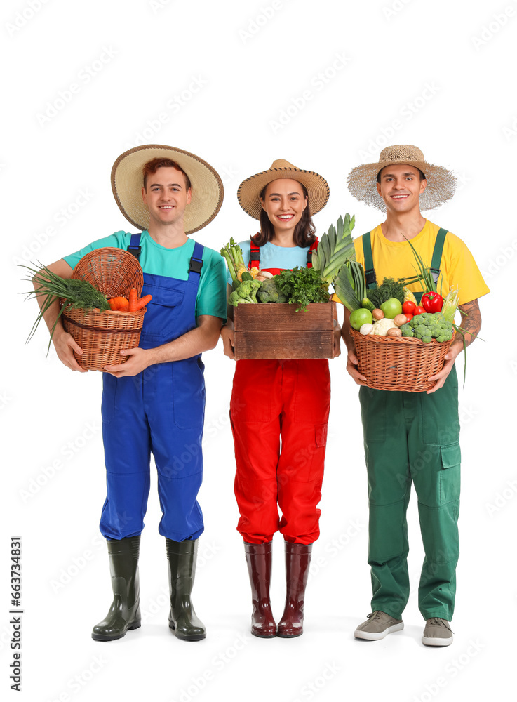 Young farmers with fresh vegetables on white background