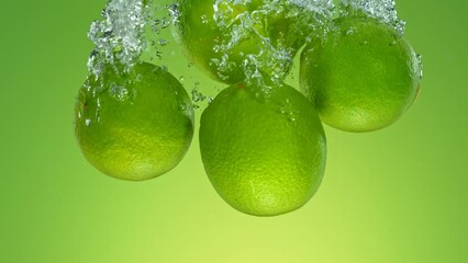 Aufkleber - Super Slow Motion of Falling Whole Limes Into Water, Isolated on Green Background. Filmed on High Speed Cinema Camera, 1000 fps.