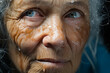 Woman with wrinkles and blue eyes looks at the camera.