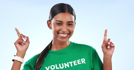 Wall Mural - Volunteer woman, face and point in studio with t shirt, help and social responsibility by blue background. Girl, community service and pride for activism, climate change and charity with job at NGO