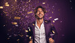 happy smiling portrait of a handsome man on purple background, celebration with golden confetti