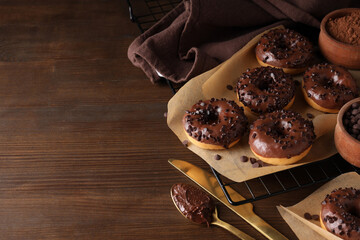 Wall Mural - Chocolate donuts on parchment, on the table.