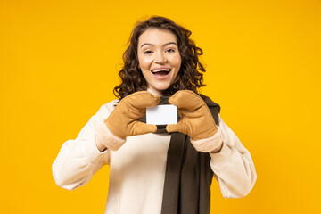 A girl in warm winter clothes, with an empty card in her hands.