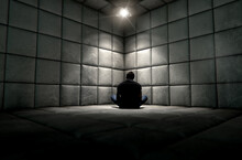 Man Sitting In Padded Cell Corner