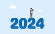 Business vision for 2024. Year review. Preparation to face new challenges in the new year.Forecast and future opportunities. businessman standing at the number 2024 while looking through binoculars