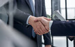 © Katsiaryna - executives shaking hands in front of their manager and a colleague