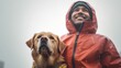 A cheerful man in a vibrant raincoat strikes a pose with his dog, both enjoying the rain on a cloudy day.