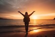 Silhouette of young woman with backpack standing on the beach at sunset
