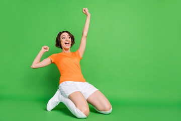 Sticker - Full body portrait of astonished lady open mouth stand on knees slide look empty space isolated on green color background