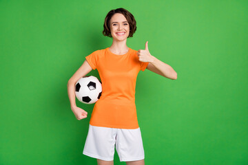 Sticker - Portrait of cheerful lady hand hold ball show thumb up approve have good mood isolated on green color background