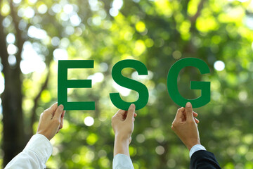 Wall Mural - ESG concept of environmental, social, and governance.Hand of business people holding a paper with the word ESG to represent doing business that participates in solving environmental, social