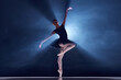 © master1305 - Elegance and grace in movements. Beautiful ballerina dancing over blue background with spotlight. Concept of classical dance, art and grace, beauty, choreography, inspiration
